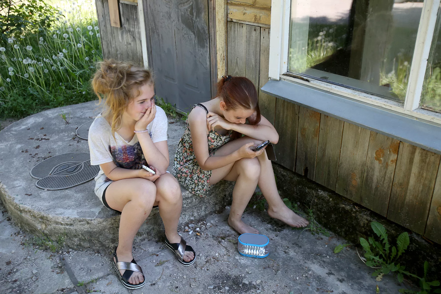 Štai šalia vienos trobos sutinkame sėdinčias Mariją ir Deimantę. Mergaitės klausosi muzikos ir šnekučiuojasi. A. Barzdžiaus nuotr.