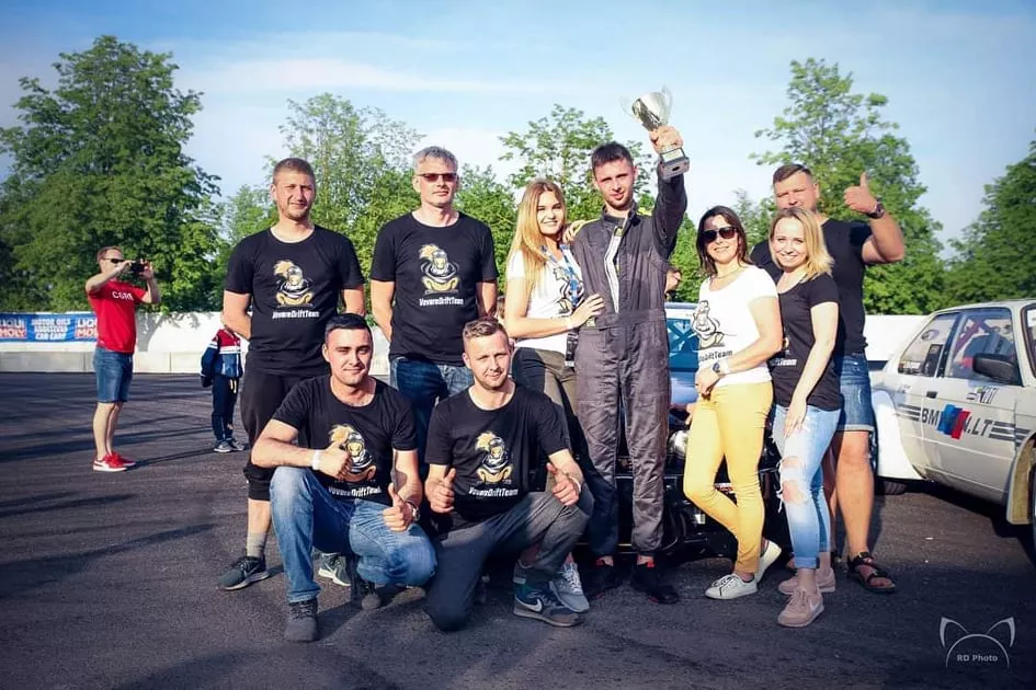 Čempionas Simonas Vilčinskas (su apranga) triumfo akimirką apsuptas artimiausių žmonių – širdies draugės Austėjos Mazuraitės, mamos Jūratės (trečia iš dešinės), tėčio Mariaus (antras iš kairės, stovi), brolio Žydrūno (pirmas iš kairės, tupi) bei draugų. / „RD Photo“ nuotr.